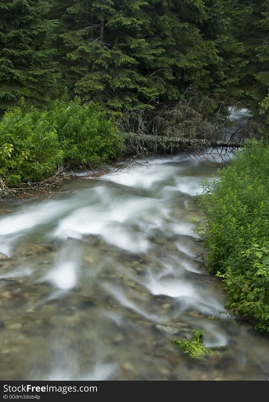 A stream or creek, is a body of water with a detectable current, confined within a bed and banks. A stream or creek, is a body of water with a detectable current, confined within a bed and banks.