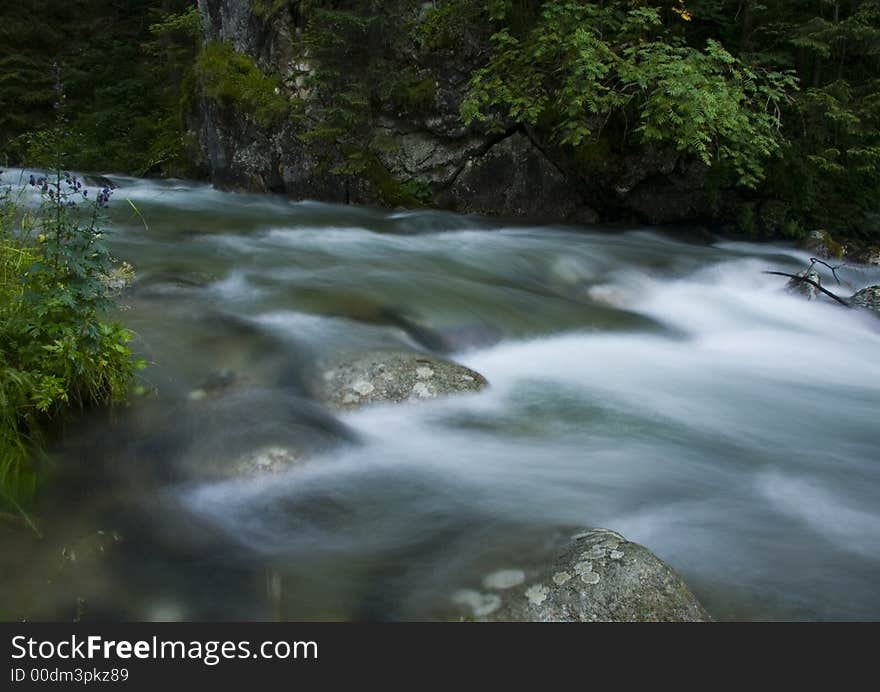 A stream or creek, is a body of water with a detectable current, confined within a bed and banks. A stream or creek, is a body of water with a detectable current, confined within a bed and banks.