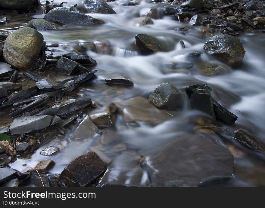 A stream or creek, is a body of water with a detectable current, confined within a bed and banks. A stream or creek, is a body of water with a detectable current, confined within a bed and banks.