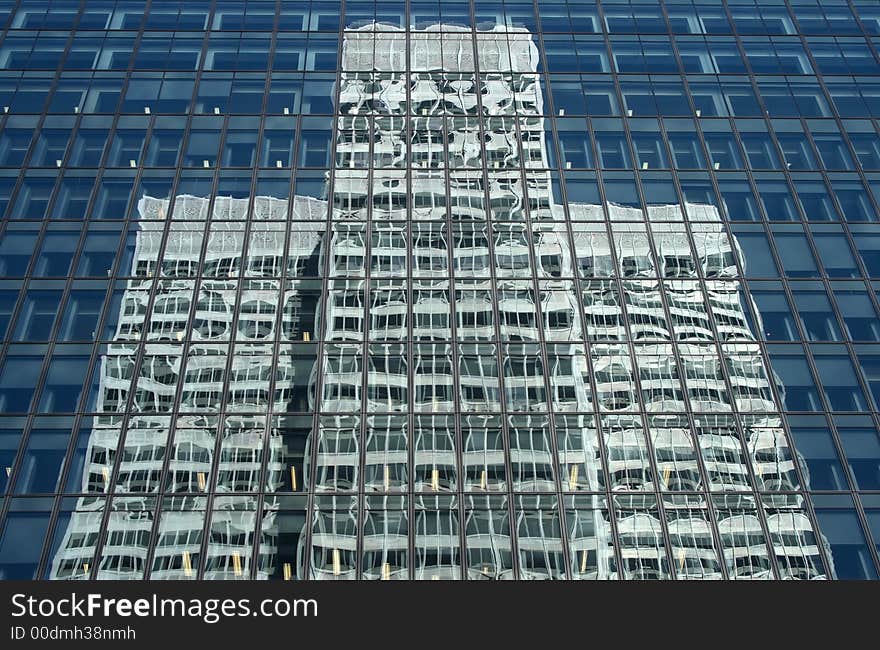 Skyscraper reflecting a white symmetrical office building. Skyscraper reflecting a white symmetrical office building.