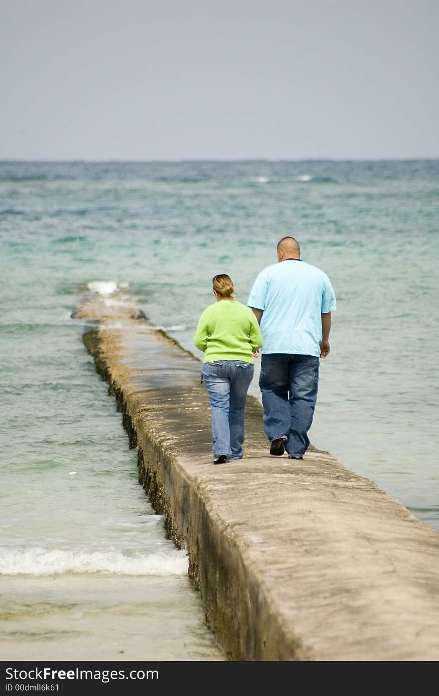 Couple walking hand and hand on a peer