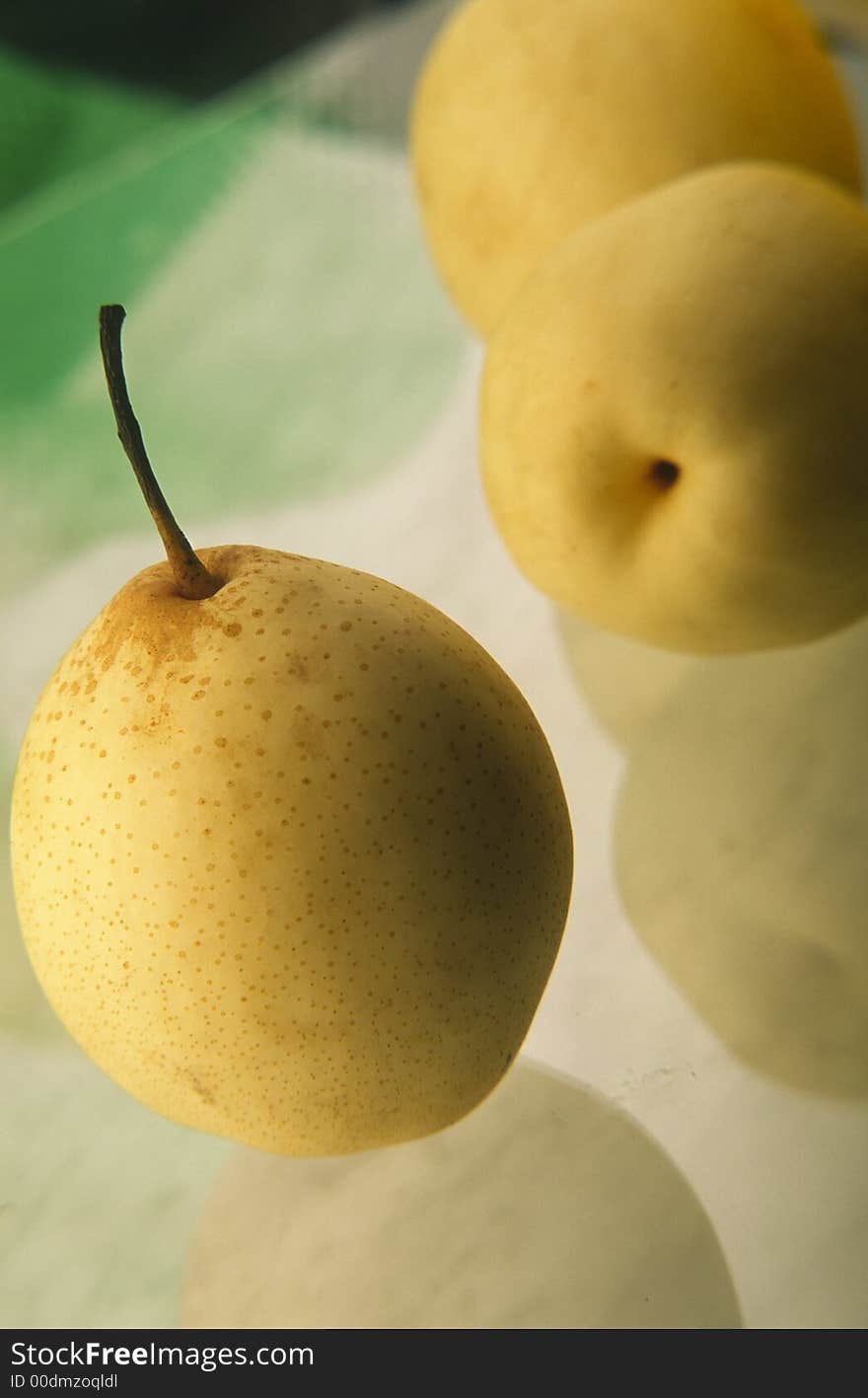 Three yellow Chinese pears on  green background