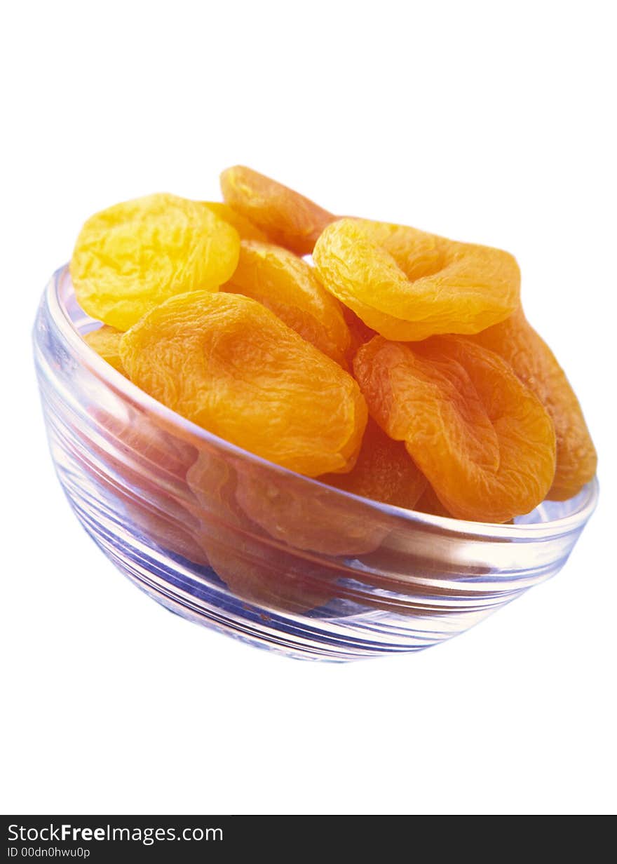 Large orange dried apricots in a glass transparent plate on a white background. Large orange dried apricots in a glass transparent plate on a white background