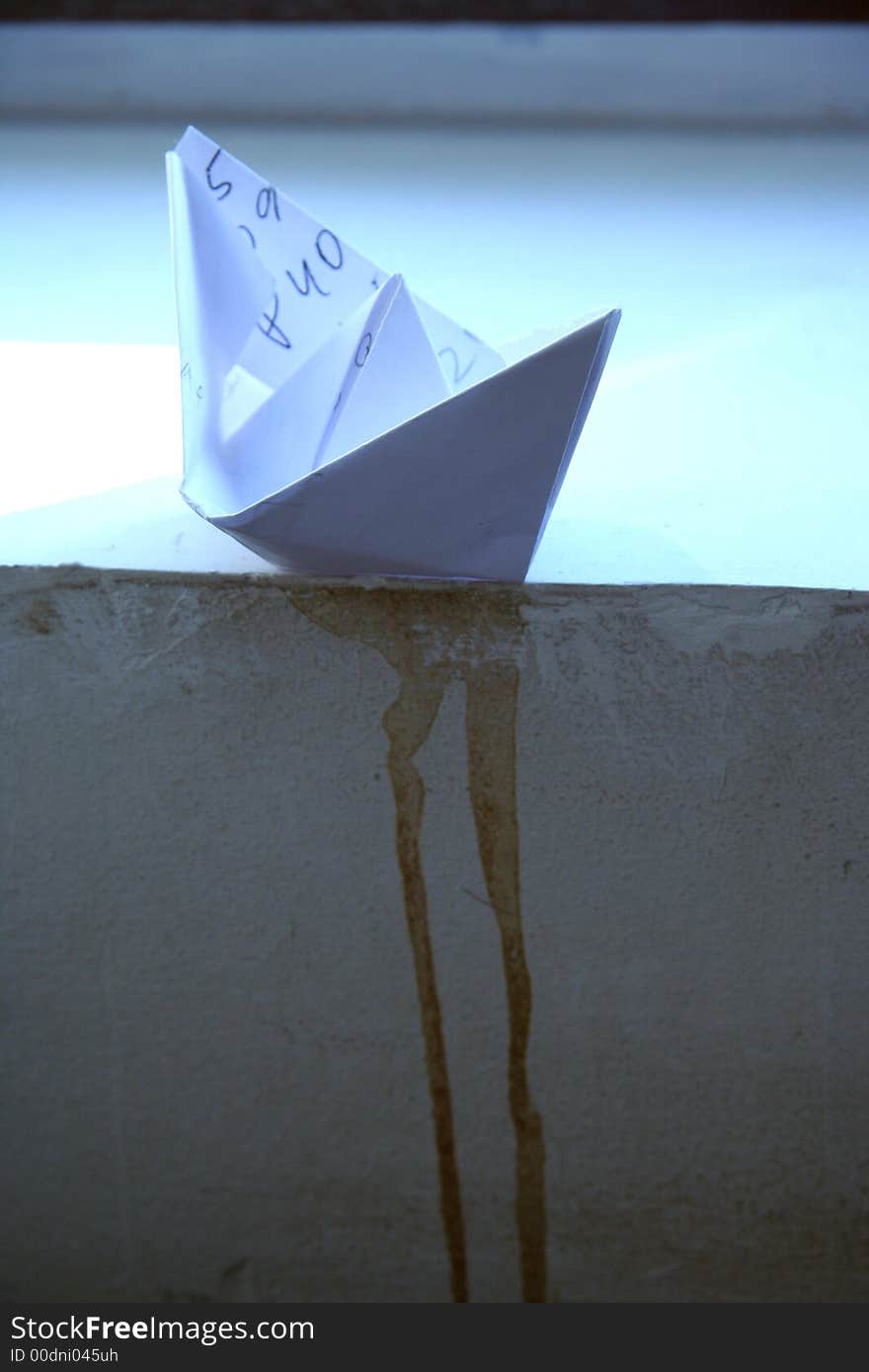 Little white boat made from paper, near the window.