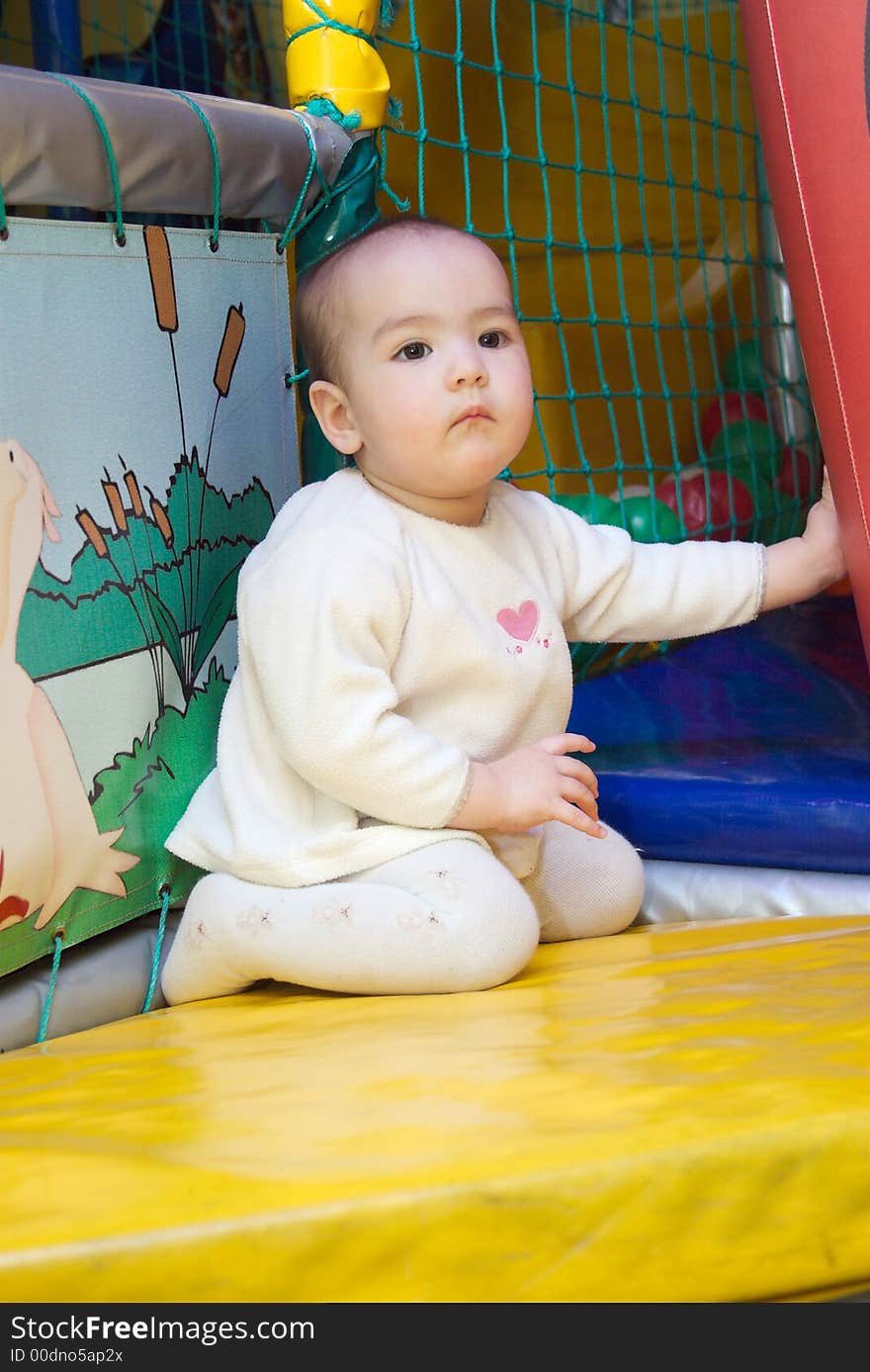 Baby sits in a children's room, among toys. Baby sits in a children's room, among toys