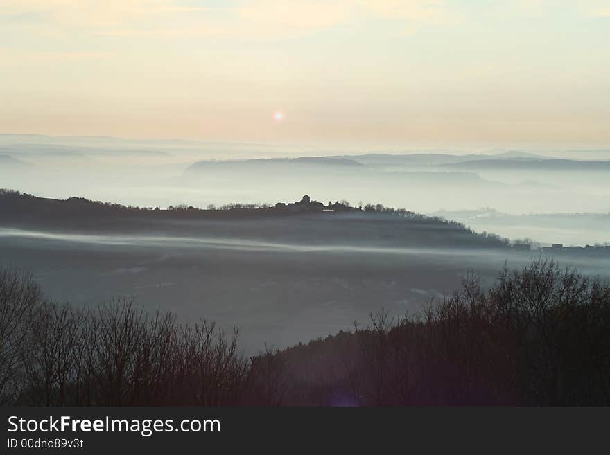 Streak of mist going through village at sunset