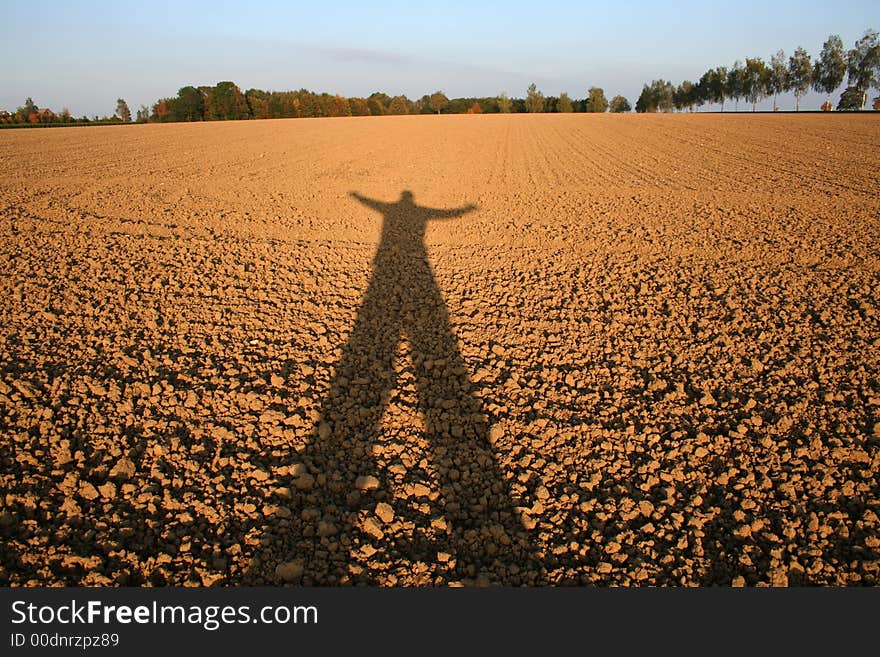 Shadow of person cast over field. Shadow of person cast over field