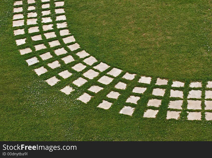 Green grass with flowers, foothpath, walkway. Green grass with flowers, foothpath, walkway