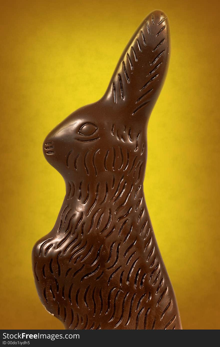 Chocolate easter bunny against a vibrant yellow background