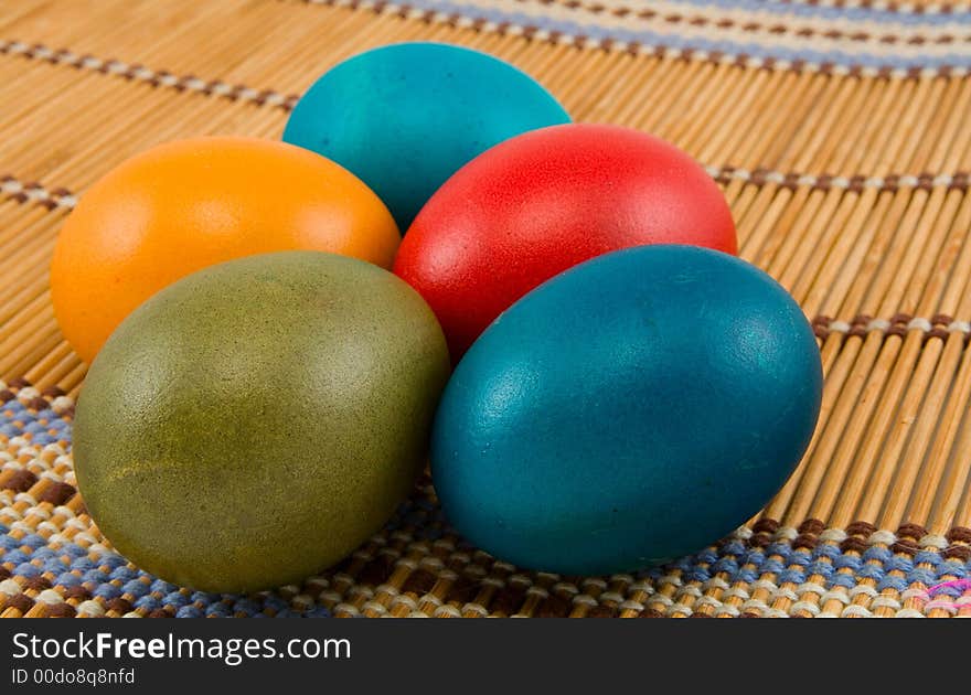 Five easter eggs on bamboo mat