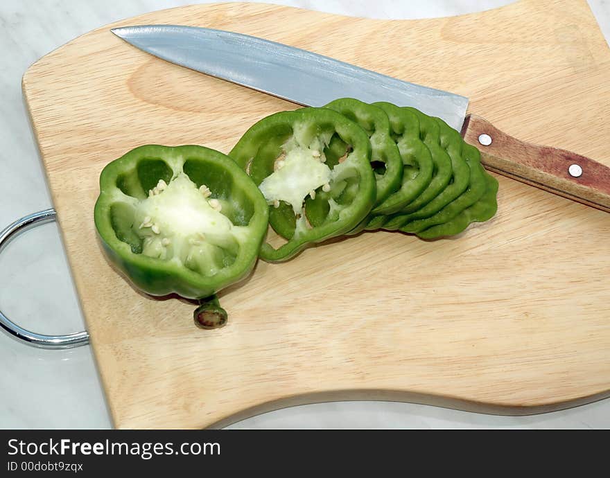 Green pepper cut on mugs on table