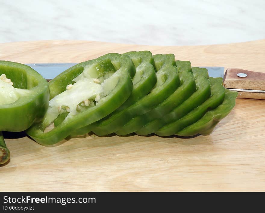 Green pepper cut on mugs on table