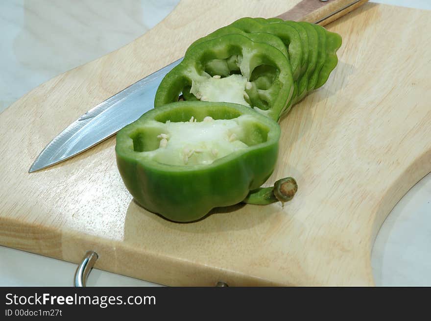 Green pepper cut on mugs on table