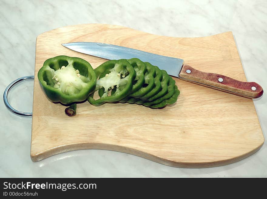 Green pepper cut on mugs on table