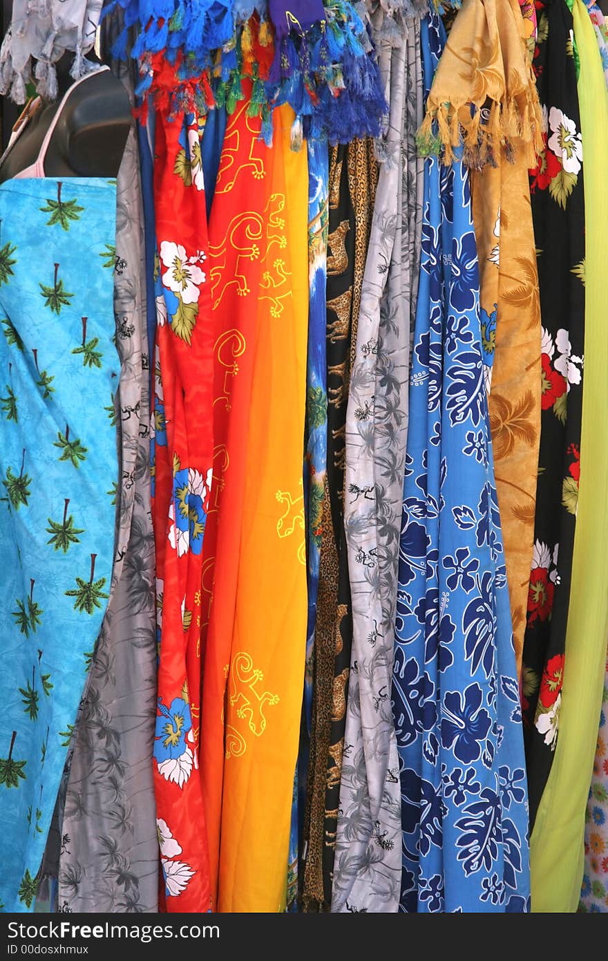 A display of colorful fabrics hanging at a market. A display of colorful fabrics hanging at a market