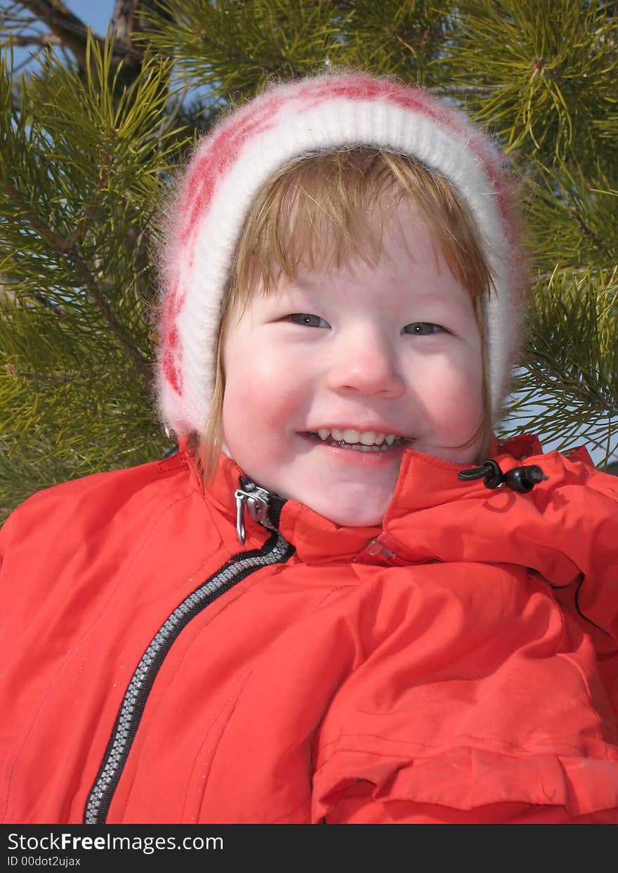 Pretty small girl in the red jacket smiles