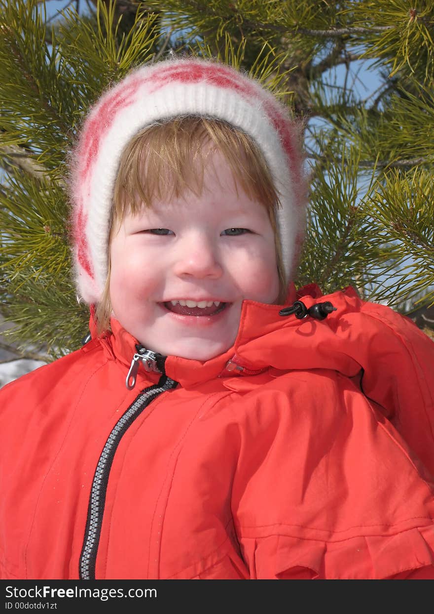 Pretty small girl in the red jacket smiles