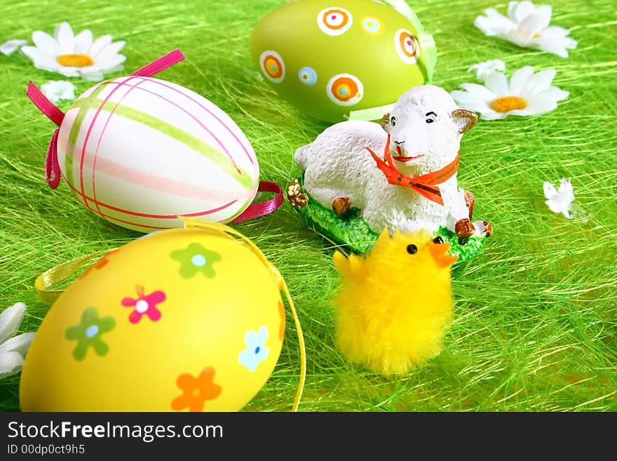 Closeup of several Easter eggs over green grass.