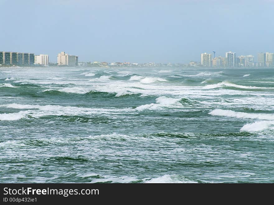 The timeless surf breaks relentlessly across the coastal beach. The timeless surf breaks relentlessly across the coastal beach