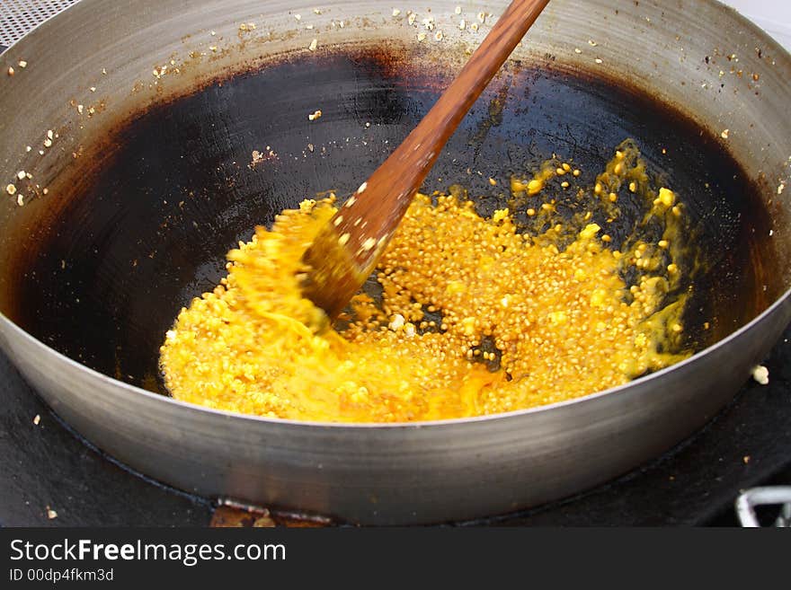 Stirring popcorn in a kettle after pouring sugar for caramel popcorn. Stirring popcorn in a kettle after pouring sugar for caramel popcorn