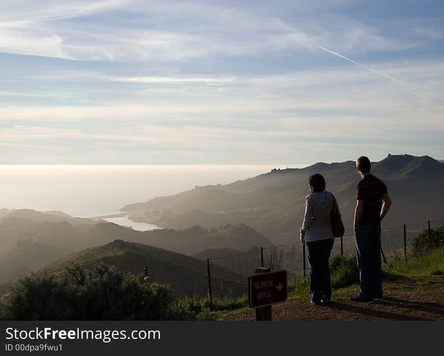 A couple watching ocean sunset. A couple watching ocean sunset