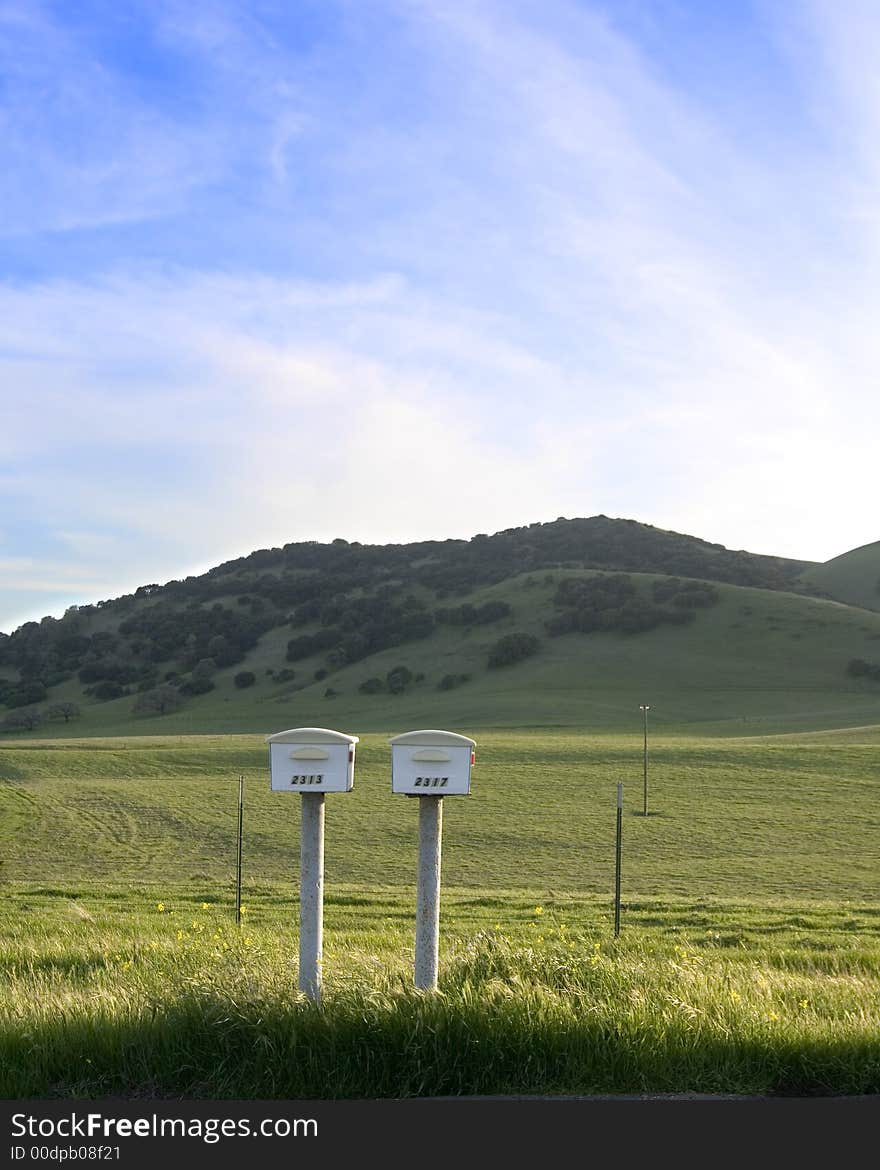 Mailboxes in the pasture, hillside in the background. Mailboxes in the pasture, hillside in the background