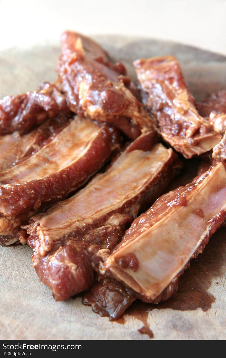 Uncooked pork ribs on a wooden chopping board