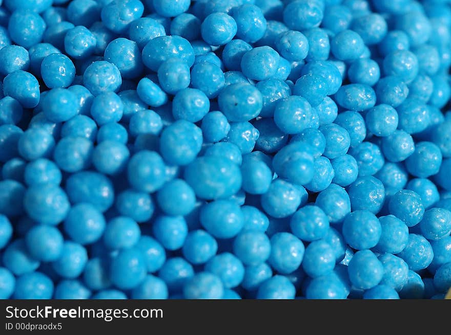 Small blue candies in a small glass on a saucer