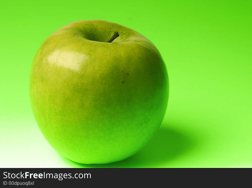 Appetizing apple of green color on a brightly green background