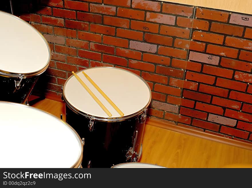 Some white drums and wooden sticks. Some white drums and wooden sticks