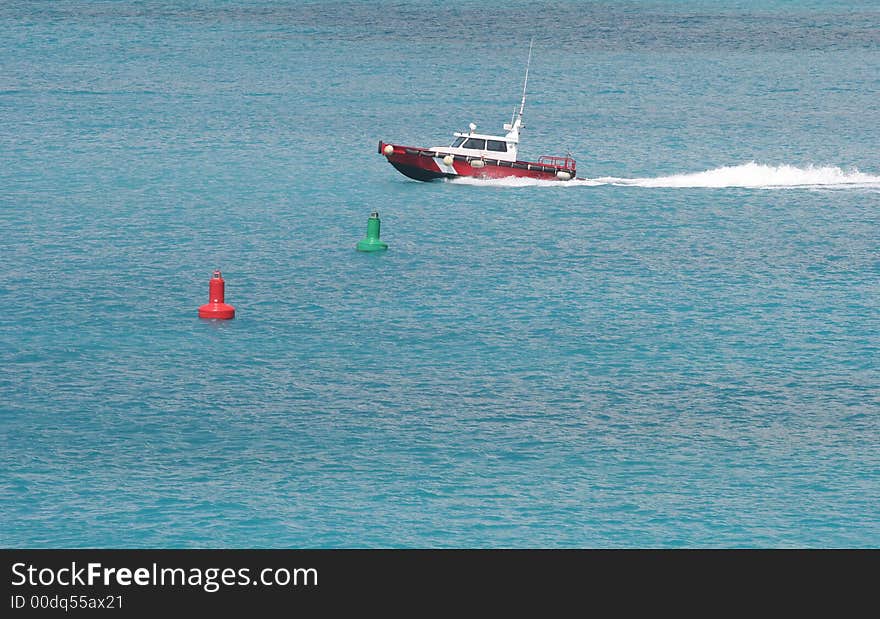 Red boat speeding through water past buoys. Red boat speeding through water past buoys