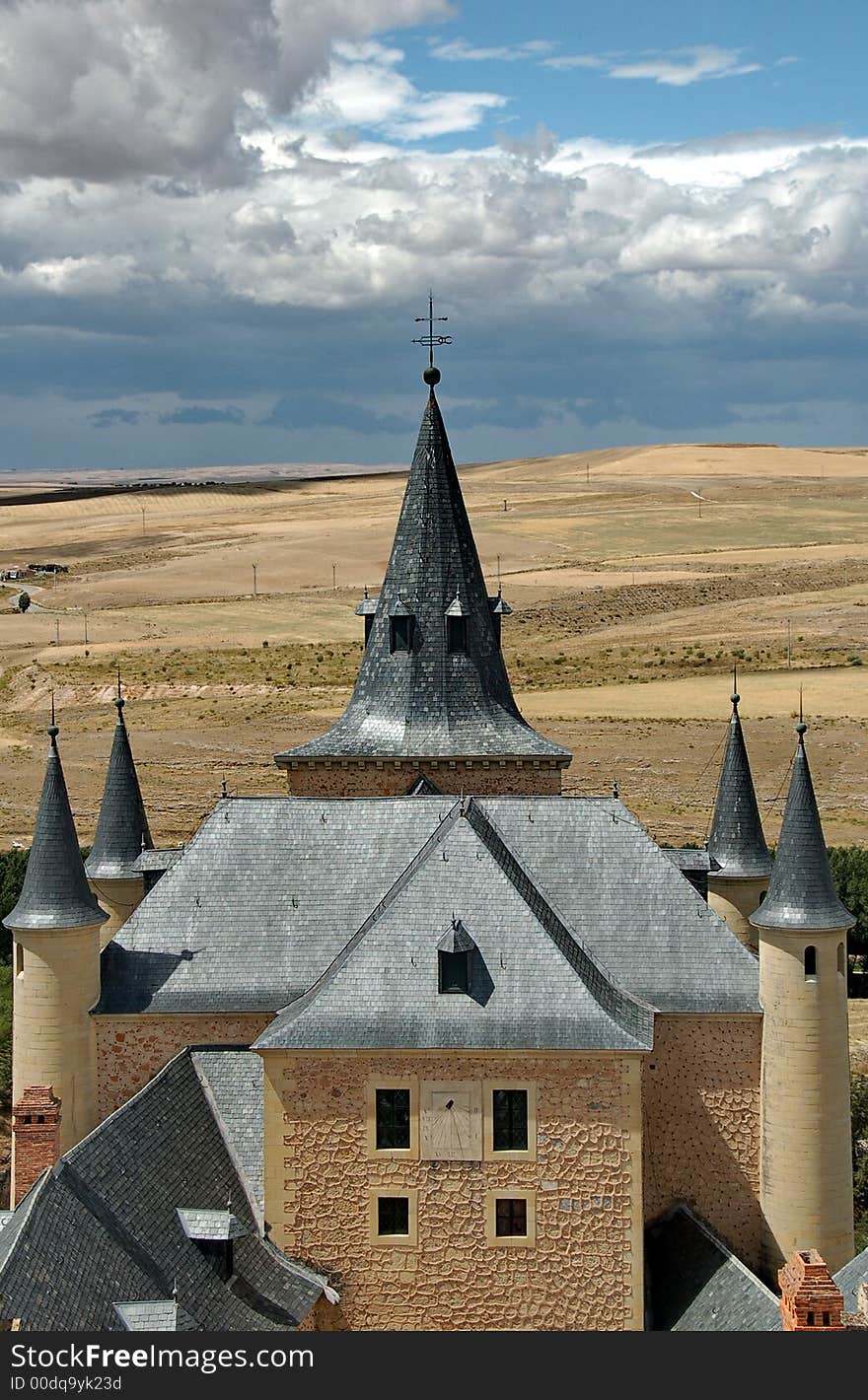 Peaky roof with sundial and cloudy sky. Peaky roof with sundial and cloudy sky