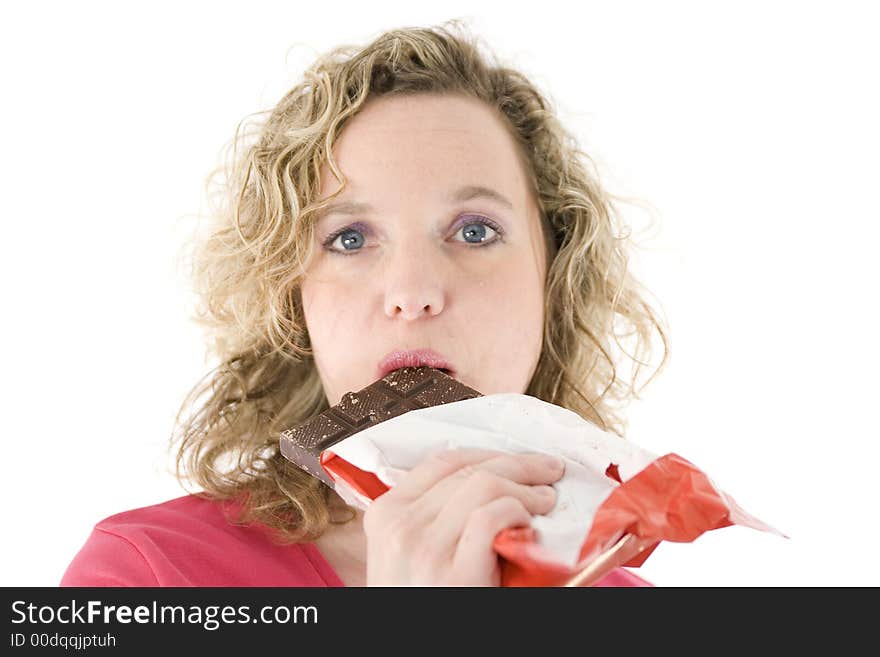 Young blond woman eats chocolate in front of the white background. Young blond woman eats chocolate in front of the white background