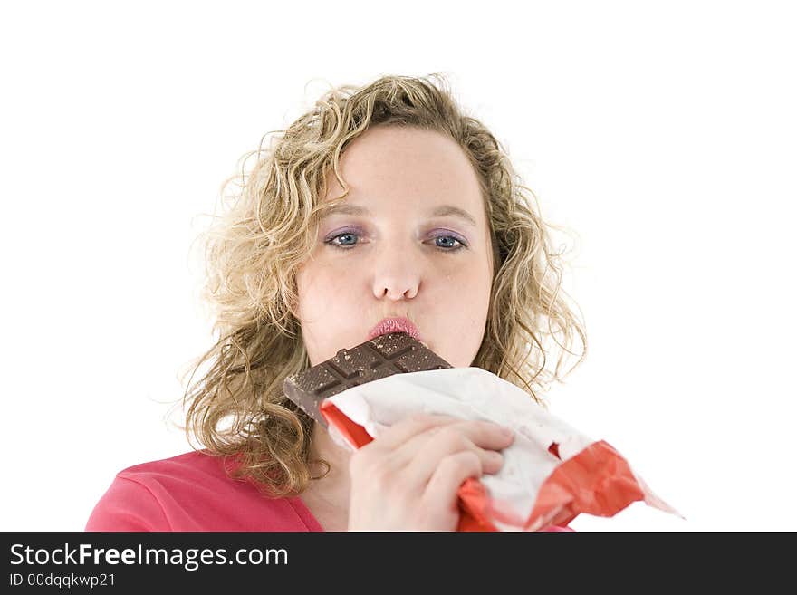 Young blond woman eats chocolate in front of the white background. Young blond woman eats chocolate in front of the white background