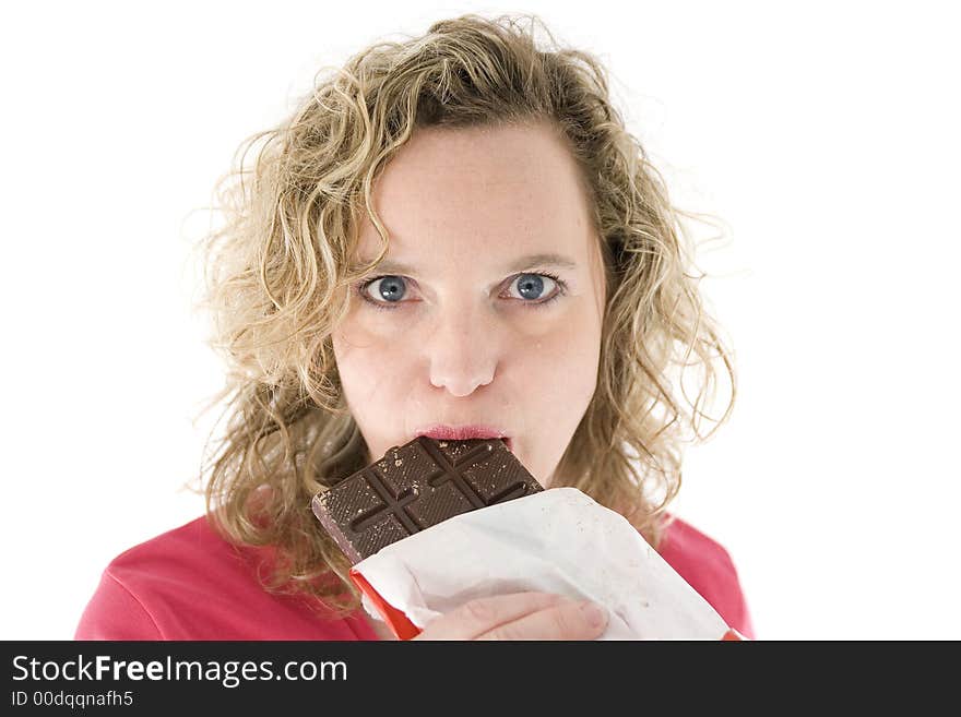 Young blond woman eats chocolate in front of the white background. Young blond woman eats chocolate in front of the white background