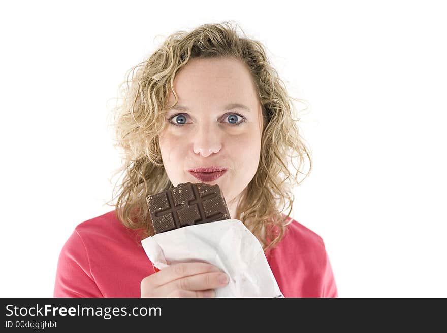 Young blond woman eats chocolate in front of the white background. Young blond woman eats chocolate in front of the white background