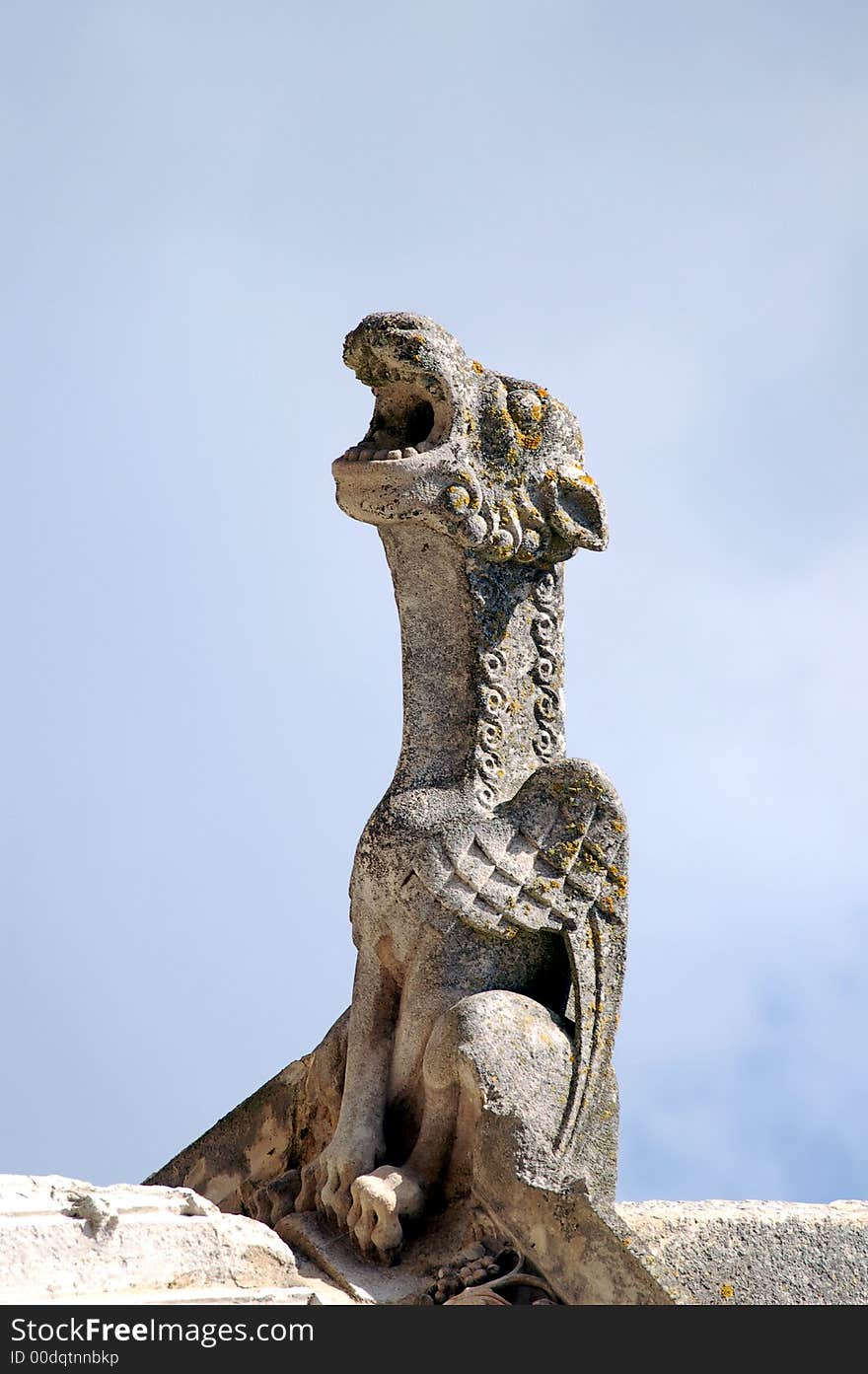 Gothic gargoyle sitting on stone