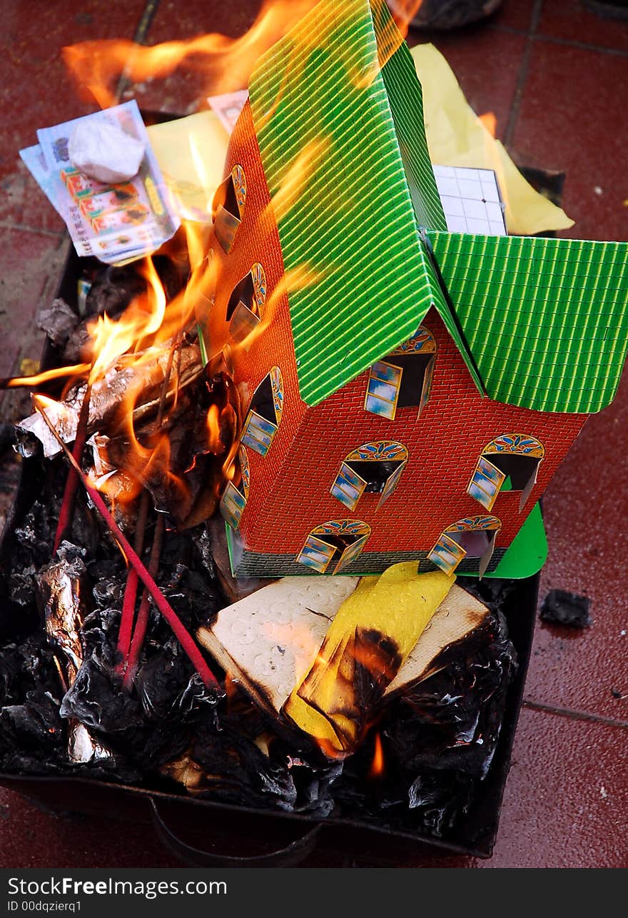 People fire paper house in a traditional cemetery in Sichuan,west of China.Chinese people visits cemetery to cherish the memory of the dead in spring annually. People fire paper house in a traditional cemetery in Sichuan,west of China.Chinese people visits cemetery to cherish the memory of the dead in spring annually.