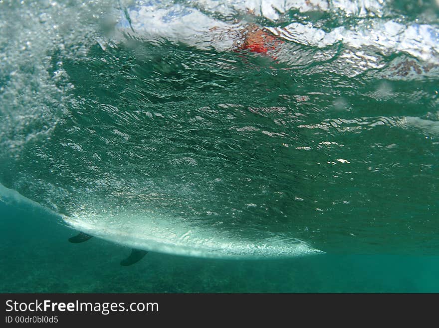 A surfer on a wave view from behind the wave