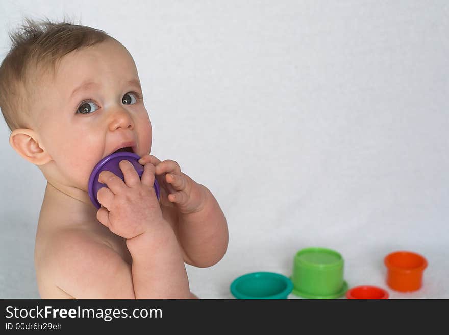 Image of adorable baby playing with colorful stacking cups. Image of adorable baby playing with colorful stacking cups