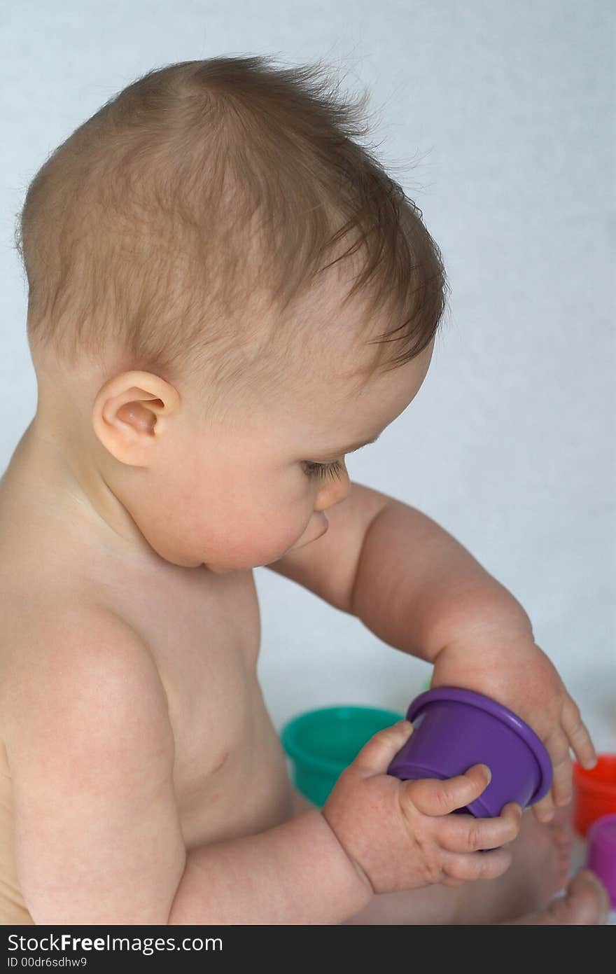 Image of adorable baby playing with colorful stacking cups. Image of adorable baby playing with colorful stacking cups