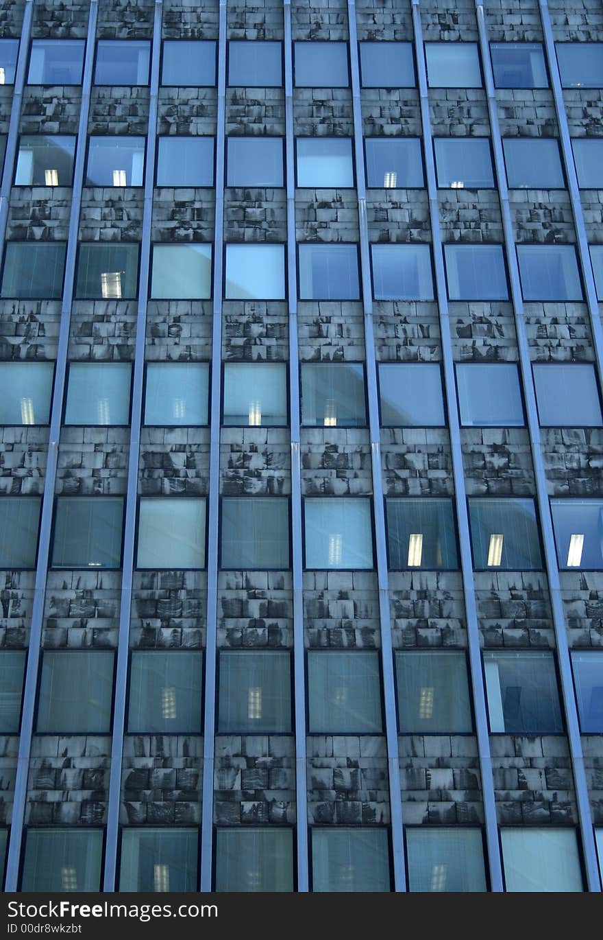 Working day in the office building. Windows with lights. Working day in the office building. Windows with lights.