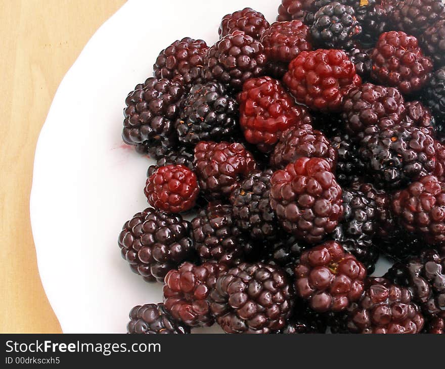 Many Blackberries close up on the white plate. Many Blackberries close up on the white plate