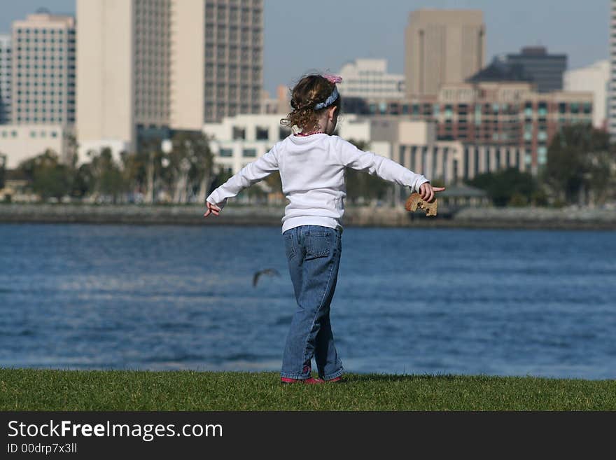 Little girl having lunch on Coronado Island and enjoying the view of San Diego downtown. Little girl having lunch on Coronado Island and enjoying the view of San Diego downtown.