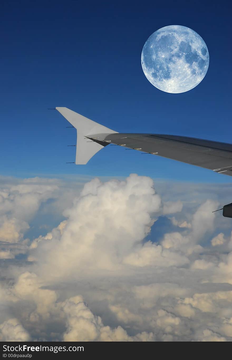 Airplane wing during a full moon flight