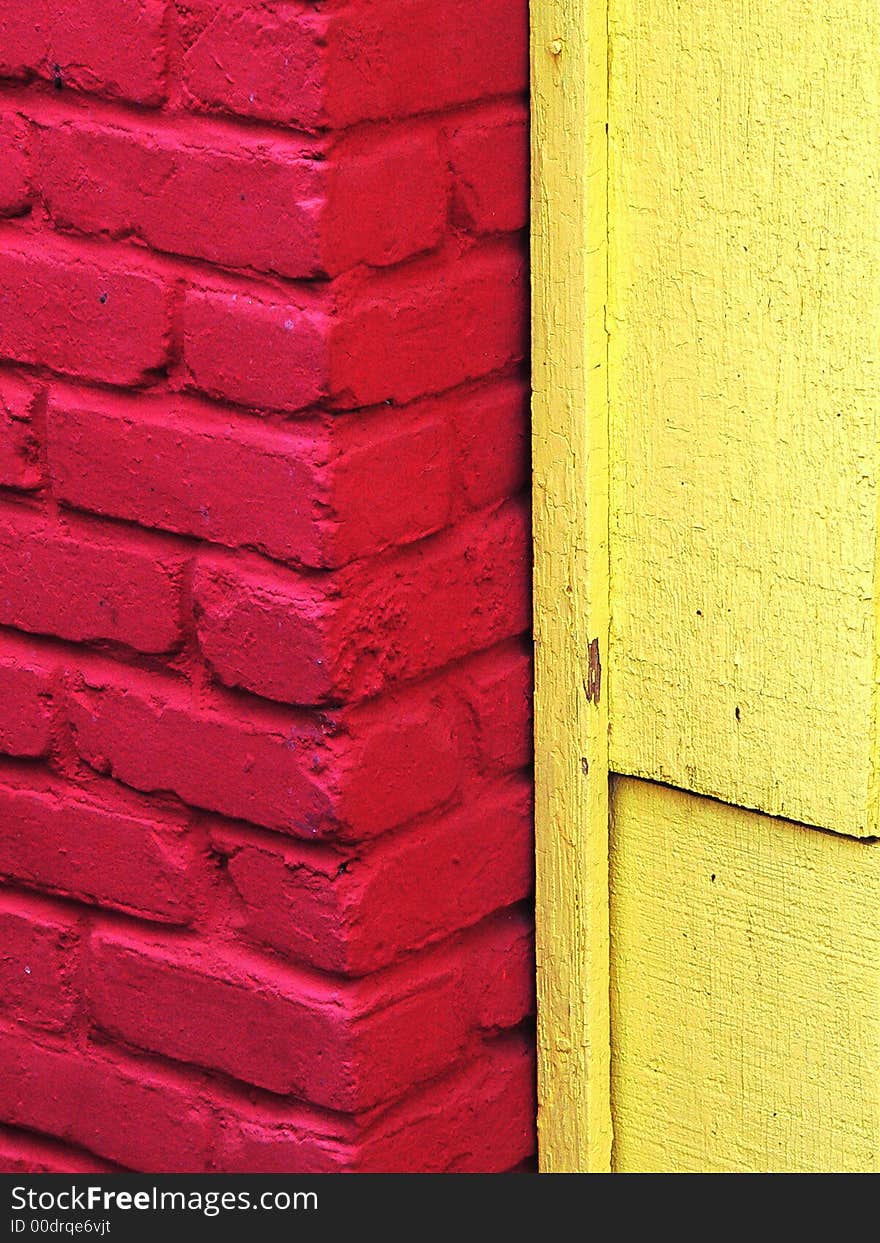 Fire engine red bricks against a lemon yellow wooden wall. Fire engine red bricks against a lemon yellow wooden wall