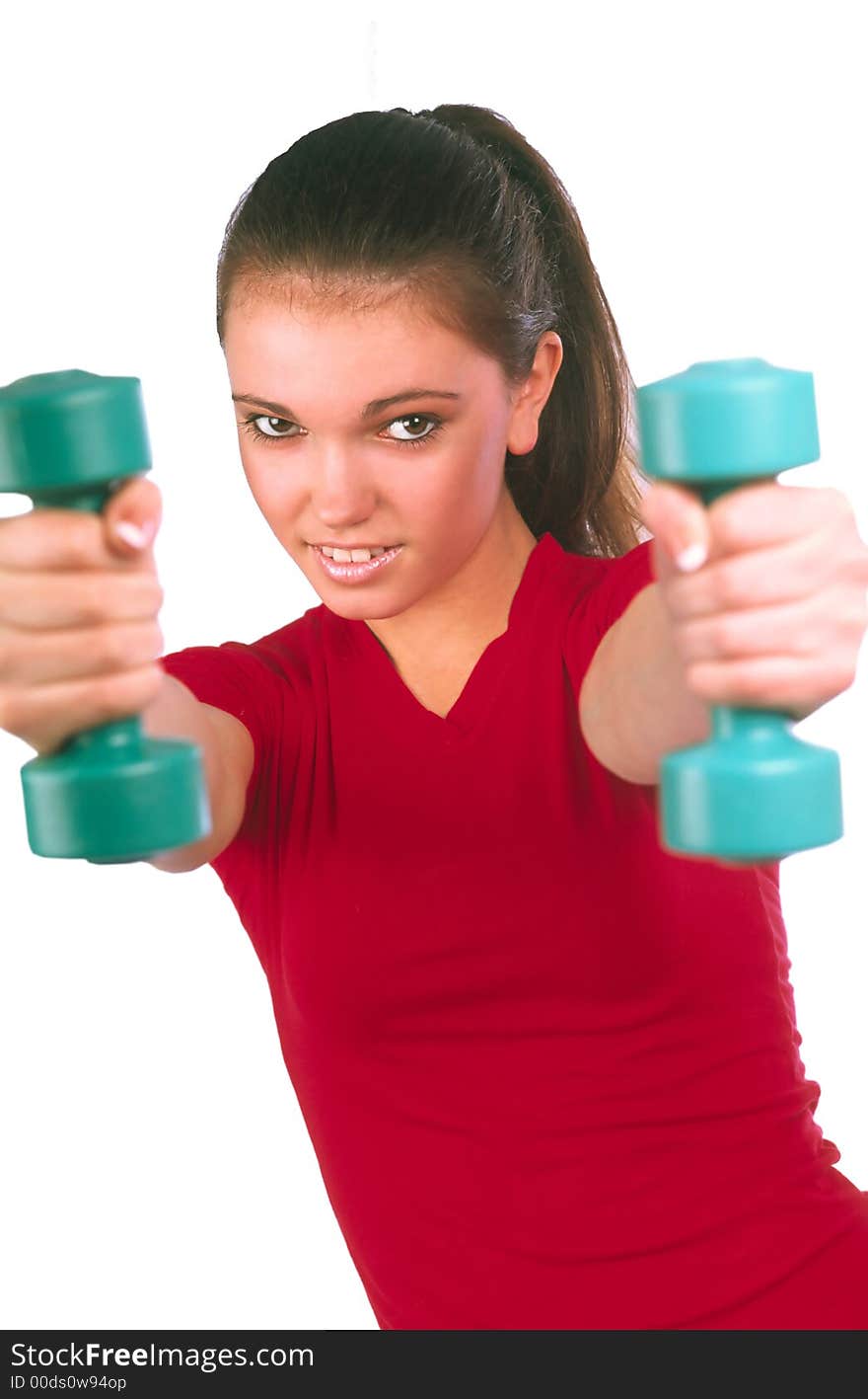 Girl in  red vest does exercises by dumbbells and aggressively looks on  white background