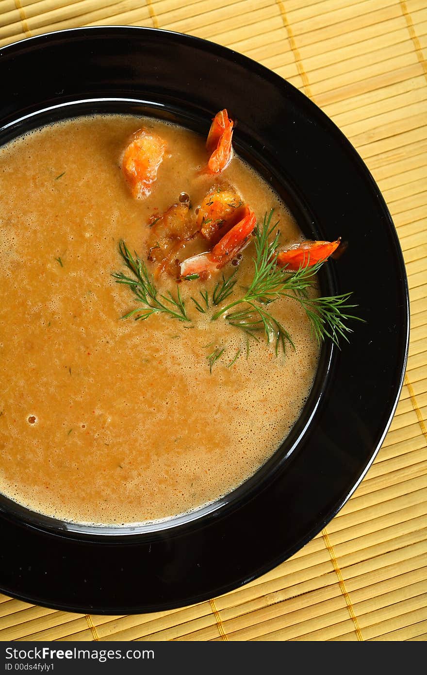 Delicious soup with shrimps and fennel in the black plate