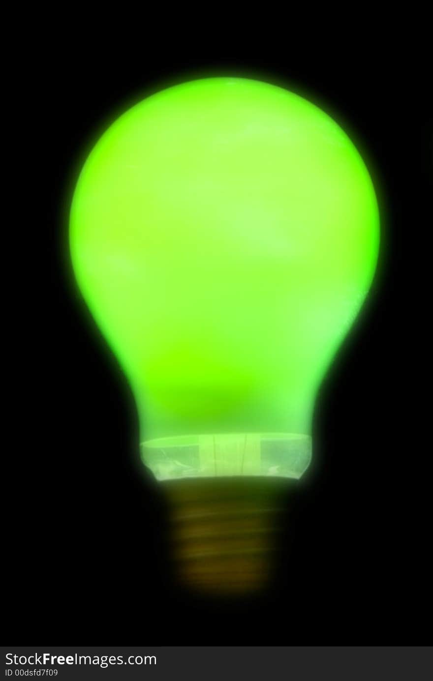 Blurry green lightbulb isolated on a black background