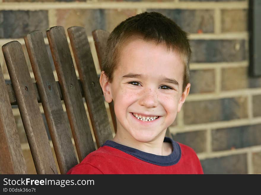 Boy on wood chair with big smile. Boy on wood chair with big smile